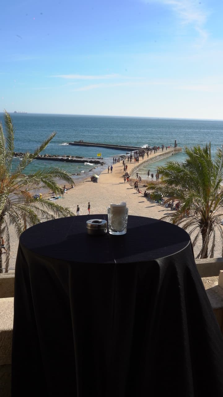 Luxurious outdoor wedding ceremony overlooking the Atlantic Ocean in Portugal at sunset with elegant floral decor and guests celebrating.